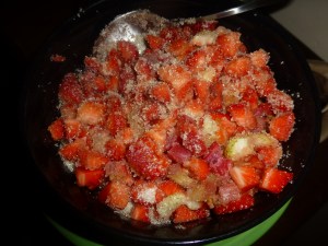 Macerating the strawberries and rhubarb with sugar and vanilla.